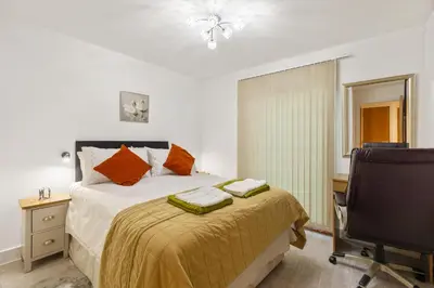 a bedroom with a bed and a desk and a chair at Khayat Homes - The Ford in Chelmsford