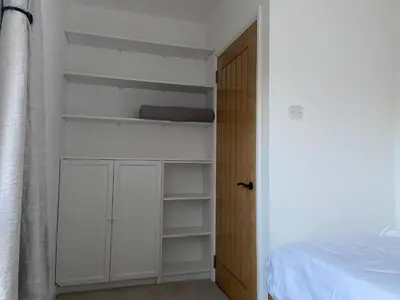 a bedroom with white shelves and a bed at Comfortable Homestay by Earith Lakes in Earith
