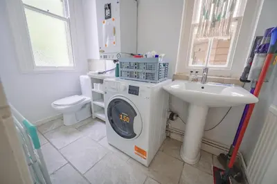 a bathroom with a washing machine and a sink at Central Victorian Villa 2 Floor I Parking I Garden in Cambridge