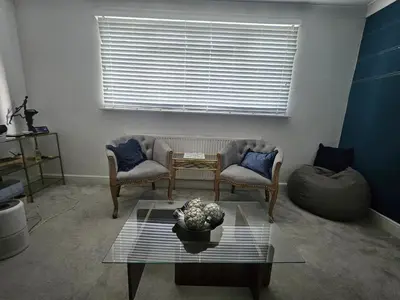 a living room with two chairs and a table and a window at Luv home with pool and cinema room