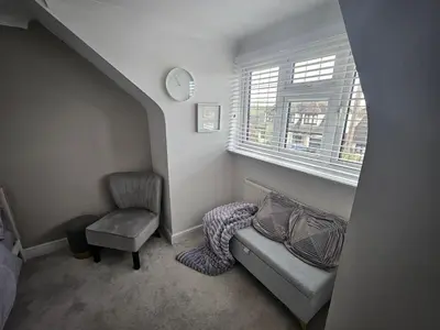 a room with a couch and a chair and a window at Luv home with pool and cinema room