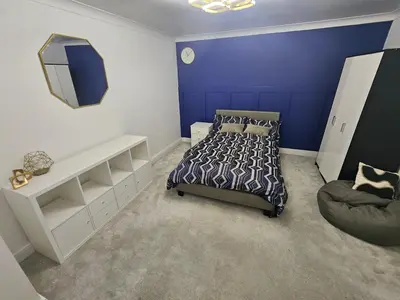 a bedroom with a bed and a chair at Luv home with pool and cinema room
