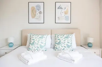 a bedroom with a bed with three pictures on the wall at 5 Bed Seaside Property with Garden , Parking and Games Room in Southend-on-Sea