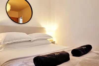 a bedroom with a bed with a large mirror on the wall at Luxury Apartment- Beach 10mins in Thorpe Bay