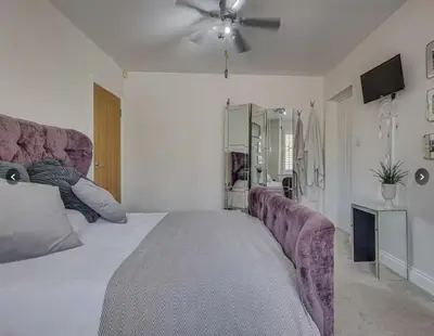 a bedroom with a large bed and a ceiling fan at Stunning home in Leigh Sleeps 5 - Pass the Keys in Southend-on-Sea