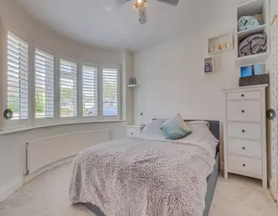 a white bedroom with a bed and windows at Stunning home in Leigh Sleeps 5 - Pass the Keys in Southend-on-Sea