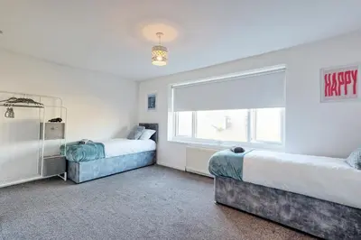 a bedroom with two beds and a large window at Modern 4BR Sleeps 10, Free Parking, Basildon town, Contractor friendly in Basildon