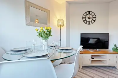 a dining room with a glass table and white chairs at Modern 4BR Sleeps 10, Free Parking, Basildon town, Contractor friendly in Basildon
