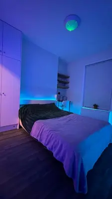 a bedroom with a bed with a blue light at 52A Flat Mill Road in Cambridge