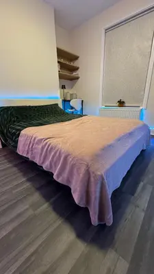 a large bed in a room with a large window at 52A Flat Mill Road in Cambridge