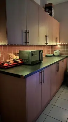 a kitchen counter with a microwave on top of it at 52A Flat Mill Road in Cambridge