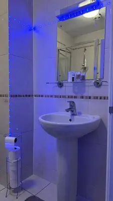 a white bathroom with a sink and a mirror at 52A Flat Mill Road in Cambridge