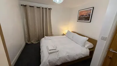 a small bedroom with a bed with towels on it at Guildford Court Apartment in Colchester in Colchester