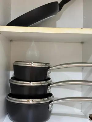 a stack of pots and pans on a shelf at Guildford Court Apartment in Colchester in Colchester