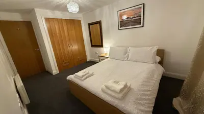 a bedroom with a bed with two towels on it at Guildford Court Apartment in Colchester in Colchester