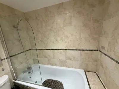 a bathroom with a bath tub with a shower at Guildford Court Apartment in Colchester in Colchester