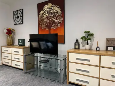 a living room with a television on a dresser at Guildford Court Apartment in Colchester in Colchester