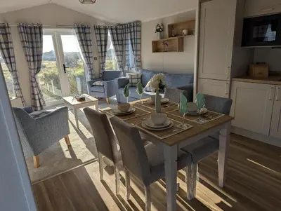 a kitchen and living room with a table and chairs at Modern 6 Berth Caravan With Decking At Suffolk Sands Ref 45004F in Felixstowe