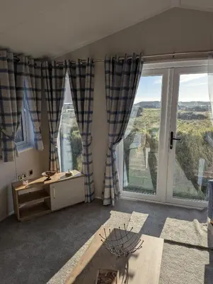a room with a desk and large windows at Modern 6 Berth Caravan With Decking At Suffolk Sands Ref 45004F in Felixstowe
