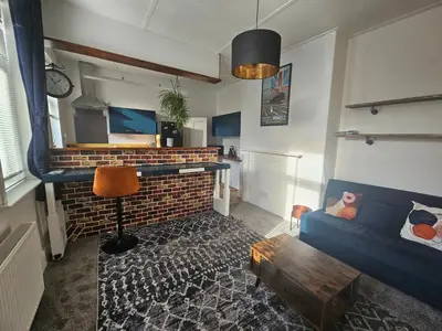 a living room with a brick fireplace and a blue couch at Station House in Roudham