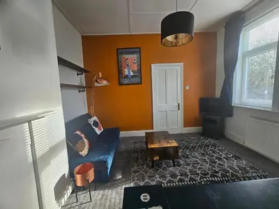 a living room with a blue couch and a table at Station House in Roudham