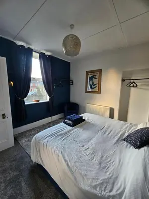 a bedroom with a large bed and a window at Station House in Roudham