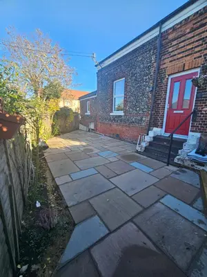 a patio in front of a brick building with a red door at Station House in Roudham