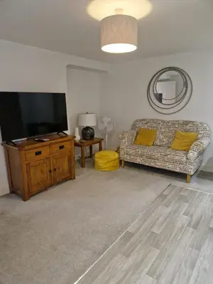 a living room with a couch and a flat screen tv at Cosy Central 1-Bed with Parking & Wi-Fi in Ipswich