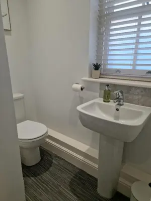 a white bathroom with a sink and a toilet at Cosy Central 1-Bed with Parking & Wi-Fi in Ipswich