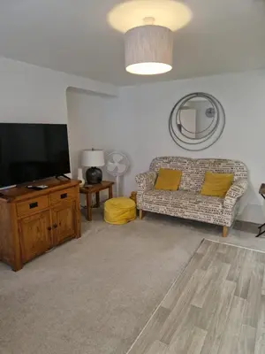 a living room with a couch and a flat screen tv at Cosy Central 1-Bed with Parking & Wi-Fi in Ipswich