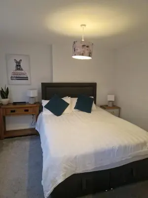 a bedroom with a large white bed with blue pillows at Cosy Central 1-Bed with Parking & Wi-Fi in Ipswich