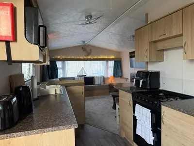 an open kitchen and living room with a couch at Coastal Beachfront Caravan in Brightlingsea