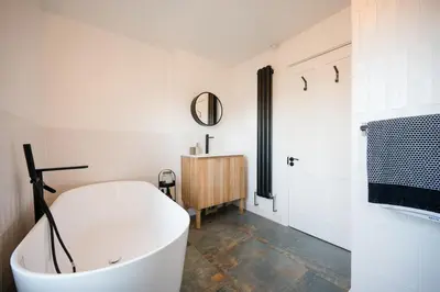 a bathroom with a white tub and a sink at 9 Chantry Road, Saxmundham in Saxmundham