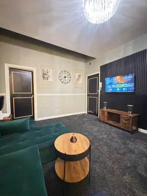 a living room with a green couch and a television at The Olive Stay by Cambridge City Centre in Chesterton
