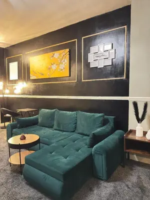 a living room with a green couch and a table at The Olive Stay by Cambridge City Centre in Chesterton