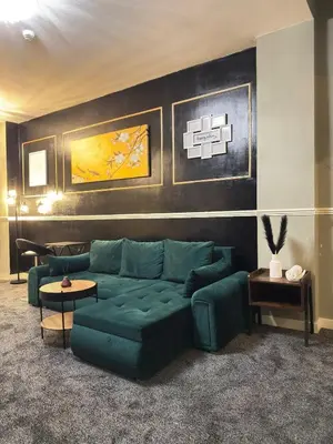 a living room with a green couch and tables at The Olive Stay by Cambridge City Centre in Chesterton