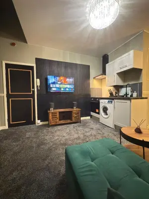 a living room with a couch and a tv at The Olive Stay by Cambridge City Centre in Chesterton