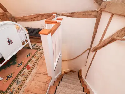 a staircase in a room with a stair case at The Hare & The Bumblebee Cottage in Eye