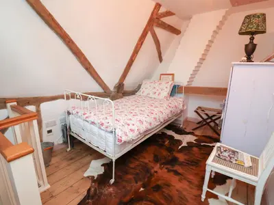 a bedroom with a bed in a attic at The Hare & The Bumblebee Cottage in Eye