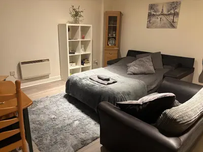 a living room with a bed and a couch at 4 Castle Walk in Stansted Mountfitchet