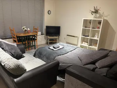 a bedroom with a bed and a couch and a table at 4 Castle Walk in Stansted Mountfitchet