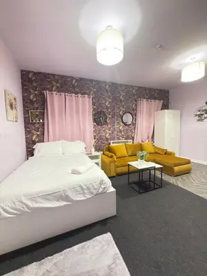 a bedroom with a bed and a couch and a table at The Lavender Stay by Cambridge City Centre in Chesterton
