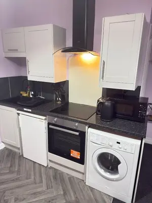 a kitchen with a washing machine and a microwave at The Lavender Stay by Cambridge City Centre in Chesterton