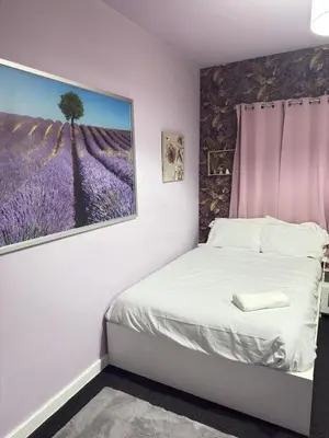 a bedroom with a bed with a painting on the wall at The Lavender Stay by Cambridge City Centre in Chesterton