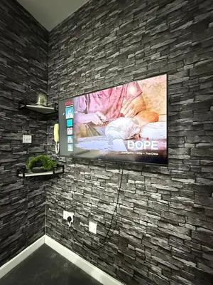 a flat screen tv hanging on a brick wall at The Charcoal Stay by Cambridge City Centre in Chesterton