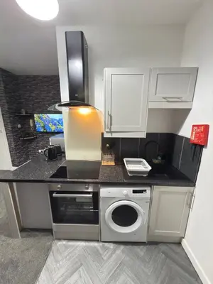 a kitchen with a counter with a washing machine at The Charcoal Stay by Cambridge City Centre in Chesterton
