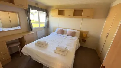 a small bedroom with a bed with towels on it at Suntrail House in Great Clacton