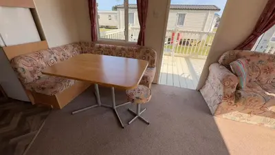 a small room with a table and a couch at Suntrail House in Great Clacton