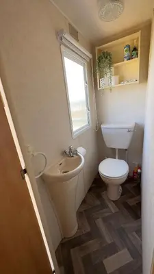 a small bathroom with a toilet and a sink at Suntrail House in Great Clacton