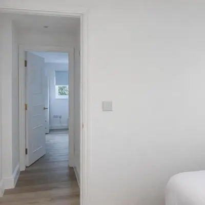 a white room with a bed and a hallway at Spacious 2BR Designer Home in Newmarket , Private Grounds & Garden in Newmarket